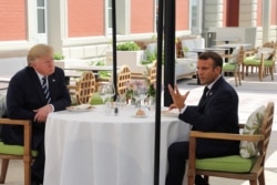 FILE - U.S. President Donald Trump sits for lunch with French President Emmanuel Macron, at Hotel du Palais in Biarritz, France, Aug. 24, 2019.