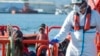 A child stands on a rescue vessel as he arrives with a group of migrants rescued by Spanish maritime authorities at Motril port in Granada, Spain, Feb. 11, 2020.