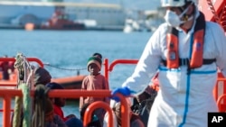 A child stands on a rescue vessel as he arrives with a group of migrants rescued by Spanish maritime authorities at Motril port in Granada, Spain, Feb. 11, 2020.