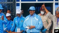 FILE - Somalia's President Mohamed Abdullahi Mohamed, center, prepares to cut the ribbon for the reopening of a stadium in Mogadishu, June 30, 2020. 