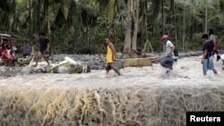 Warga mengangkat korban banjir bandang pasca hantaman topan Bopha di kota kecil New Bataan di Compostela Valley, Filipina (5/12).