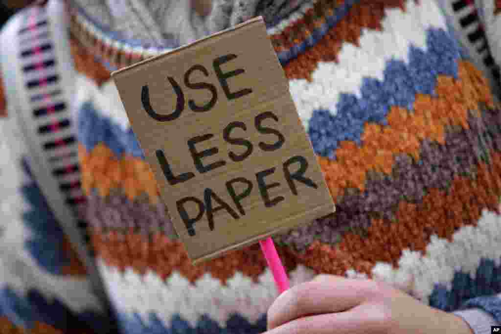 Un manifestante sostiene un pequeño cartel en Lisboa que invita a usar menos papel. Los estudiantes de todo el mundo se saltan las clases el viernes para salir a las calles a protestar por el fracaso de sus gobiernos en tomar medidas suficientes contra el calentamiento global.