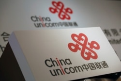 FILE - Company logos of China Unicom are displayed at a news conference during the company's announcement of its annual results in Hong Kong, March 16, 2016.