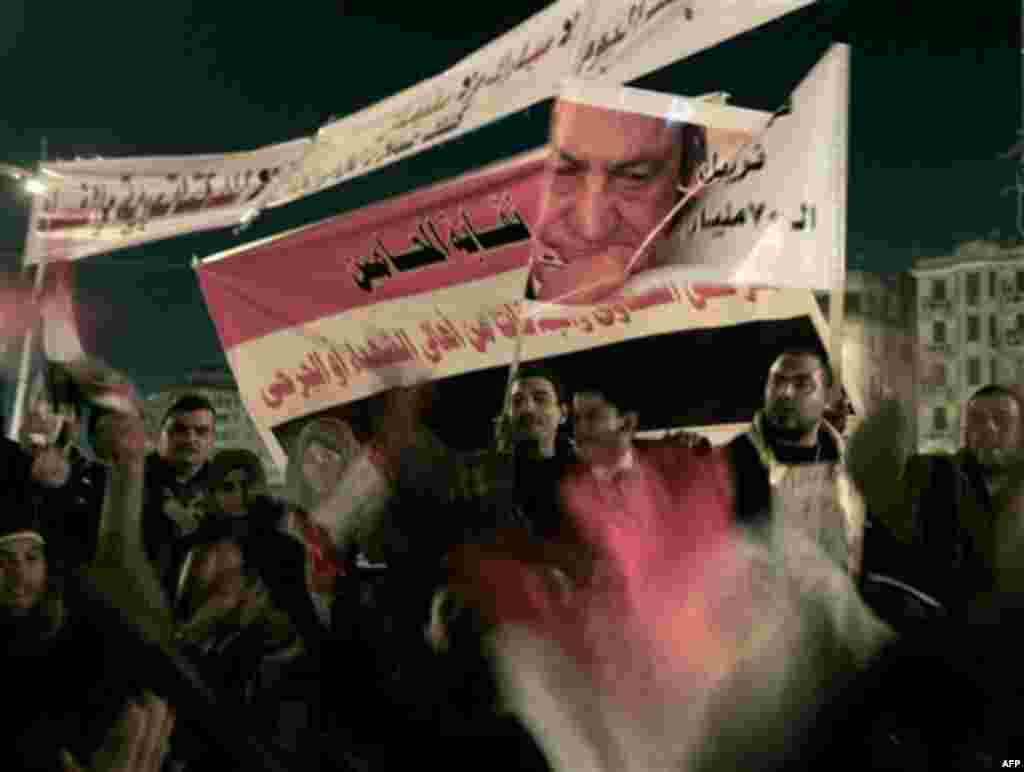 Anti-government protesters celebrate as they raise a poster showing President Hosni Mubarak and "in Arabic read 70 billion dollars?" in Tahrir Square in downtown Cairo, Egypt Thursday, Feb. 10, 2011. Egypt's military announced on national television it ha