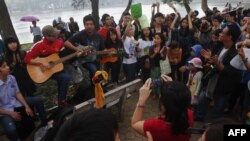 FILE - People sing during a rally protesting against a tree-felling plan by the municipal authorities in Hanoi, March 22, 2015.