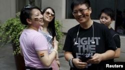 FILE – A 2015 Pride Run in Shanghai celebrates lesbian, gay, bisexual and transgendered people. But most LGBT Chinese hide their sexual orientation, fearing discrimination, a new UN report finds.