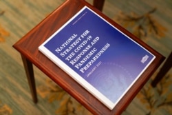 A booklet titled "National Strategy for the COVID-19 Response and Pandemic Preparedness" rests on a table in the White House, Jan. 21, 2021.