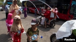 Warga Surabaya, termasuk anak-anak, membawa botol plastik bekas untuk ditukarkan dengan tiket Suroboyo bus di Terminal Purbaya (REUTERS/Sigit Pamungkas).