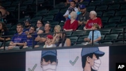 A videoboard at Globe Life Field reminds fans of the proper way to wear a mask during a baseball game between the Los Angeles Angels and the Texas Rangers in Arlington, Texas, Aug. 3, 2021. Masks are not required at the stadium.