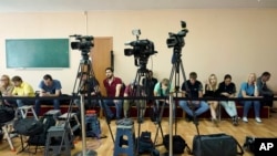 FILE - Journalists wait for President Volodymyr Zelenskiy's arrival at a polling station during parliamentary elections, in Kyiv, Ukraine, July 21, 2019. 