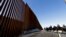 FILE - Mounted Border Patrol agents ride along a newly fortified border wall structure in Calexico, California, Oct. 26, 2018. The U.S. program to send asylum-seekers back to Mexico to wait out their U.S. court proceedings has been expanded to the Calexico port.