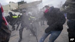 Trump supporters try to break through a police barrier, Wednesday, Jan. 6, 2021, at the Capitol in Washington. As Congress prepares to affirm President-elect Joe Biden's victory, thousands of people have gathered to show their support for President Donald