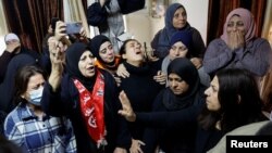 Para pelayat, termasuk kerabat, bereaksi saat pemakaman seorang pemuda Palestina Omar Mana yang tewas ditembak pasikan Israel, di Tepi Barat yang diduduki Israel, 5 Desember 2022. (Foto: REUTERS/Mussa Qawasma)