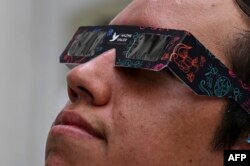 FILE—An employee of the Secretary of Citizen Security shows special sunglasses to observe the next solar eclipse, which are sold to the public at the Police Museum in Mexico City on April 4, 2024.