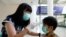 A teacher checks a student with thermal scanner at school after Indonesia confirmed its first cases of coronavirus disease (COVID-19), in Tangerang near Jakarta, Indonesia, March 6, 2020. 
