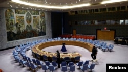 FILE - Security agents walk with sniffer dogs as they check the United Nations Security Council hall before a meeting to discuss the Israel-Hamas conflict in Gaza, at the U.N. headquarters in New York, Aug. 3, 2024.