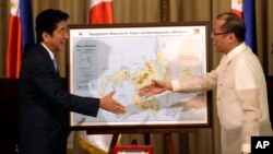 Thủ tướng Nhật Shinzo Abe, trái, bắt tay Tổng thống Philippines Benigno Aquino III trong cuộc họp báo chung tại Manila, Philippines, 27/7/2013