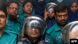 Journalists Shakil Ahmed, fifth from the left, and Farzana Rupa, third from the right, are taken to a court in Dhaka, Bangladesh, on Aug. 22, 2024.