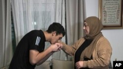 Released 17-year-old Palestinian prisoner Muhammad Abu Al-Humus, kisses his mother's hand after arriving home in east Jerusalem, Nov. 28, 2023.