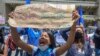 A woman holds a poster that reads "Abortion is prenatal murder" during a demonstration against the abortion law in front of the Supreme Court of Justice in Bogota, on October 14, 2021.