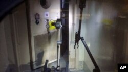 A remote-controlled robot called "Packbot", which has capabilities including maneuvering through buildings, taking images, and measuring radiation levels, opens a door at Tokyo Electric Power (TEPCO) Co.'s crippled Fukushima Daiichi Nuclear Power Plant No