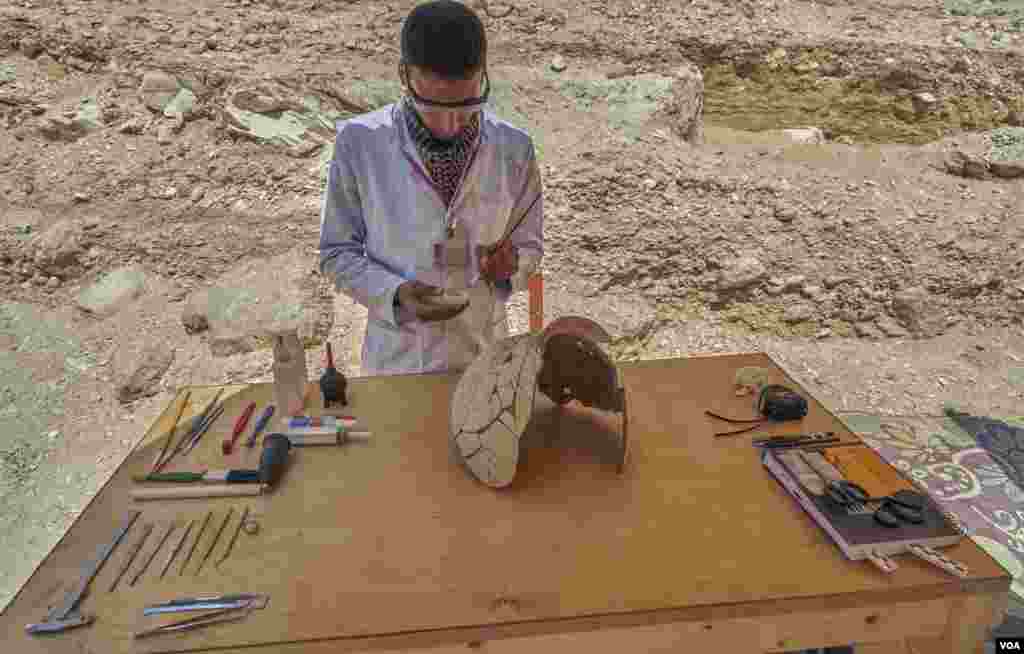 Egyptian archeologist Mohamed Said piecing together pottery found inside the workmen huts in the Luxor&#39;s Valley of Monkeys in Egypt. (H. Elrasam/VOA) 