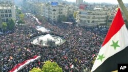 In this handout photograph released by Syria's national news agency SANA, supporters of Syria's President Bashar al-Assad attend a rally at al-Sabaa Bahrat square in Damascus, Syria, November 28, 2011.
