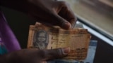 FILE - A person counts South Sudanese pounds in Juba on April 28, 2016. 