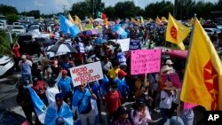 Manifestantes llevan carteles durante la protesta pacífica contra el entonces proyecto de ley 1718 del Senado de Florida, el jueves 1 de junio de 2023, en Immokalee, Florida.