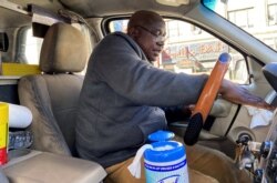 Yellow taxi cab driver Martin Oseseyi cleans his cab with disinfectant wipes amid the coronavirus outbreak in midtown Manhattan in New York City, March 4, 2020.