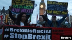 Demonstrators hold placards during a protest in favor of amendments to the Brexit Bill outside the Houses of Parliament, in London, Britain, March 13, 2017.