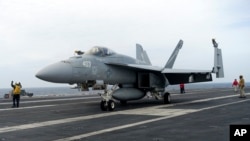 A F-18E parks on the flight deck of a USS Theodore Roosevelt aircraft carrier on Thursday, April 11, 2024 during a three-day joint naval exercise by the U.S., Japanese and South Korea at the East China Sea.