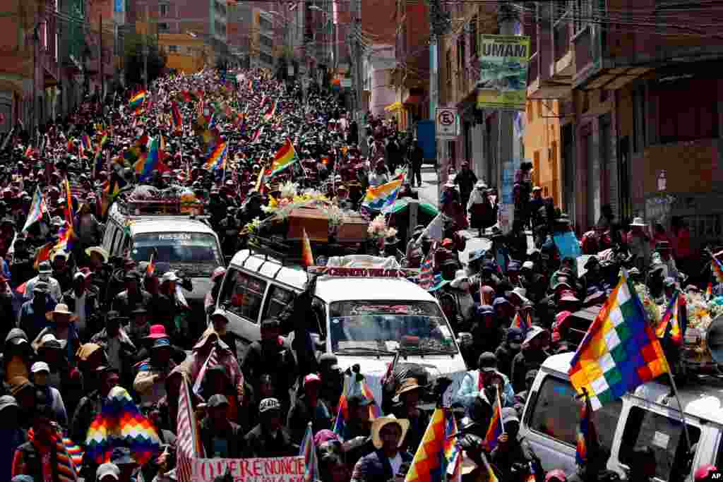 Anti-government demonstrators accompany the coffins that contain the remains of people killed in clashes between supporters of former President Evo Morales and security forces, in a funeral procession into La Paz, Bolivia.