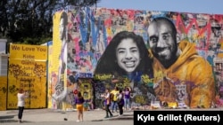 Para fans berkumpul di depan mural mendiang pebasket NBA, Kobe Bryant, dan putrinya Gianna Bryant, dalam acara doa bersama untuk mereka dan tujuh orang lainnya yang tewas dalam kecelakaan helikopter, di Los Angeles, California, 24 Februari 2020. (Foto: Reuters)