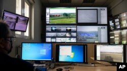 A police officer works inside the operation center at the village of Nea Vyssa near the Greek - Turkish border, Greece, May 21, 2021.