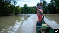 Bernardino Mosquera, a river guardian, maneuvers on water near Paimado, Colombia, Sept. 23, 2024.