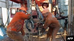 Казахстанские рабочие трудятся под Актюбинском в Казахстане на месторождении, права на разработку которого принадлежат китайской компании China National Petroleum Corp.