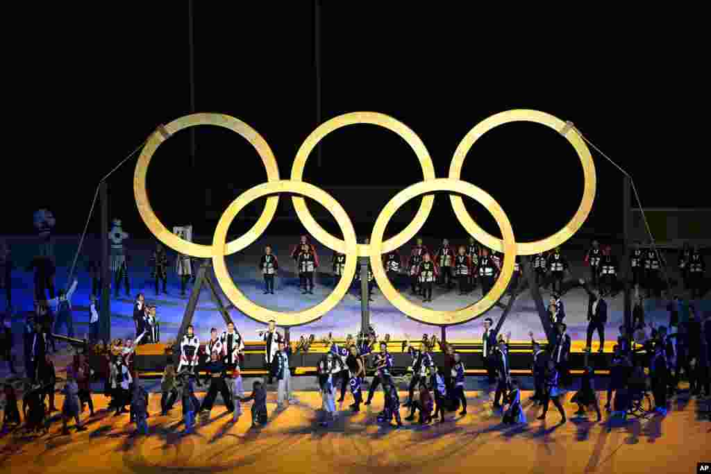 Dancers perform in front of the Olympic rings during the opening ceremony in the Olympic Stadium at the 2020 Summer Olympics, July 23, 2021, in Tokyo, Japan.