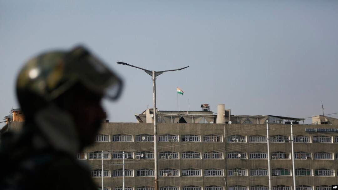 An Indian paramilitary soldier stands guard as the Indian national flag flies atop the government secretariat in Srinagar, Indian controlled Kashmir, Oct. 31, 2019. 