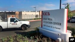 FILE - A vehicle drives into the Otay Mesa Detention Center in San Diego, California. Authorities say a 57-year-old person in immigration custody has died from complications related to the coronavirus.