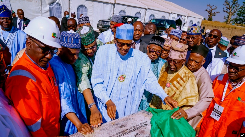 In this photo released by the Nigeria State House, Nigeria's President Muhammadu Buhari, center, looks at a plaque marking the start of drilling for oil at the Kolmani project in northeast, Nigeria, Tuesday, Nov. 22, 2022. 