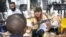 Musician Kelly Grevler gives guitar lessons to underprivileged children on a sidewalk in central Johannesburg. (D. Taylor/VOA)