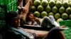 A worker holds his cell phone as he rests next to watermelons at the Kramat Jati central market in Jakarta, March 4, 2011. 