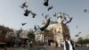 Burung-burung merpati terbang di luar Masjid Shah-e Doh Shamshira saat orang-orang bergegas untuk salat Ied untuk merayakan Idulfitri di Kabul, Afghanistan, 15 Juni 2018. (Foto: Reuters)