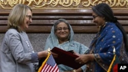 Bangladesh prime minister Sheikh Hasina, center, looks on as U.S. Secretary of State Hillary Rodham Clinton, left, and Bangladesh Foreign Minster Dipu Moni exchange signed agreements in Dhaka, Bangladesh, Saturday, May 5, 2012. (AP Photo/Pavel Rahman)