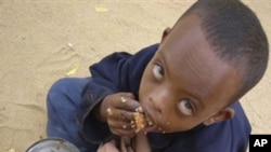 In this file photo of Thursday June 26, 2009, a Somali child eats as he is waiting to be registered at U.N. registration center in Dagahaley, Northeastern Kenya