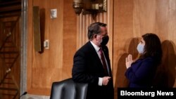 Neera Tanden talks with Sen. Gary Peters, after testifying before the Senate Homeland Security and Government Affairs committee on her nomination to become the Director of the Office of Management and Budget, during a hearing Feb. 9, 2021 on Capitol Hill.