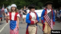 미국 매사추세츠주 케이프 코드의 반스트블 마을에서 7월 4일 독립기념일을 맞아 아이들이 성조기를 들고 행진하고 있다. 