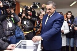 Presidential candidate Abdelaziz Belaid casts his ballot inside a polling station, in Algiers, Algeria, Dec. 12, 2019.