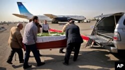 Iranian men load the coffin of a dead hajj pilgrim who was killed in a deadly stampede in Mina near Mecca in Saudi Arabia on September 24, into a car at Mehrabad airport in Tehran, Iran, Oct. 3, 2015.